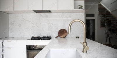 a modern kitchen, focused on the kitchen sink with a brass faucet