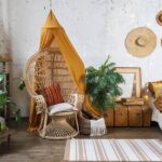 A bohemian-inspired bedroom with natural materials and neutral colors. There's a hanging egg chair in the corner.