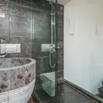A modern bathroom with porcelain materials in various places, including the tub, shower tiles, and flooring.