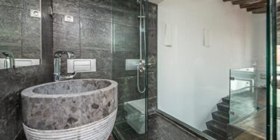 A modern bathroom with porcelain materials in various places, including the tub, shower tiles, and flooring.