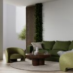 A modern living room area with neutral tones everywhere, except the dark green couch and accent chair.