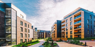 A collection of luxury apartment buildings, each with its own unique style, sharing a common courtyard and walkways.