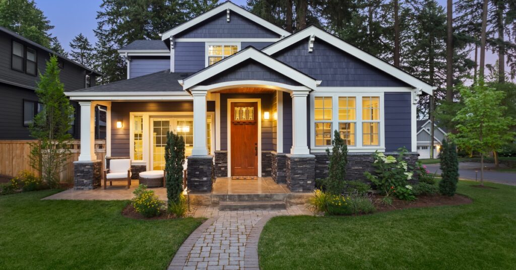 A beautiful home exterior with gray siding and roofing that goes well with the white accents around the house.