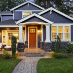 A beautiful home exterior with gray siding and roofing that goes well with the white accents around the house.