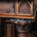 What to Look for When Buying Handmade Furniture A close-up view of a carved wooden table corner with curved legs, a polished brown surface, and intricate designs.