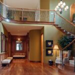 Luxury Staircase Details That Elevate Custom Homes Luxury home interior with curved staircase, wood floors, chandelier lighting, and detailed trim in the entry hall.