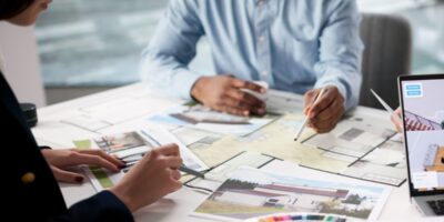 Two interior designers sit at the table to collaborate a home's design finishes, colors, and textures.