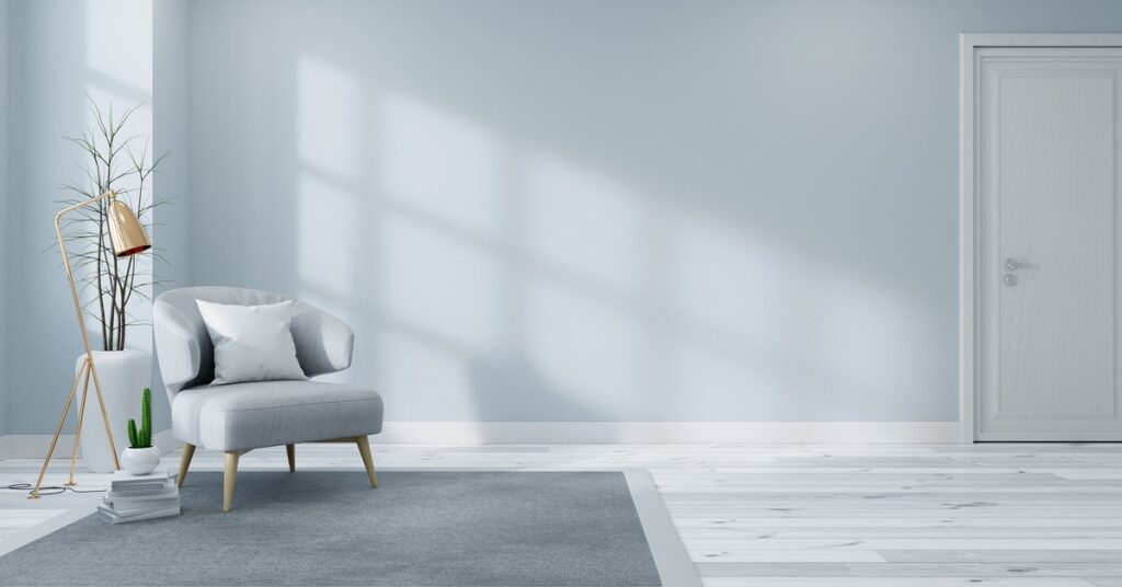 Sunlight shining through a window in a living room. The living room has light blue walls and a small light blue chair.