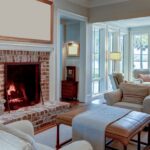 Warm and Cozy: Take Your Fireplace From Good to Great A cozy living room with white and neutral tone pieces. The fireplace has a brick surround and a white photo above it.